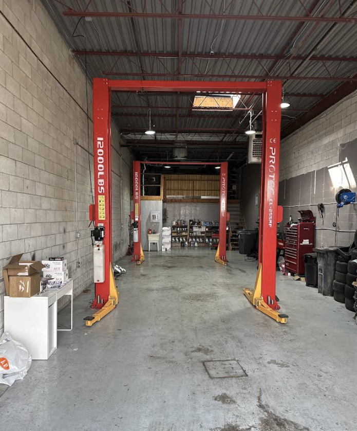 Inside the Zaib Auto Centre workshop, showing two vehicle hoists and a clean shop floor